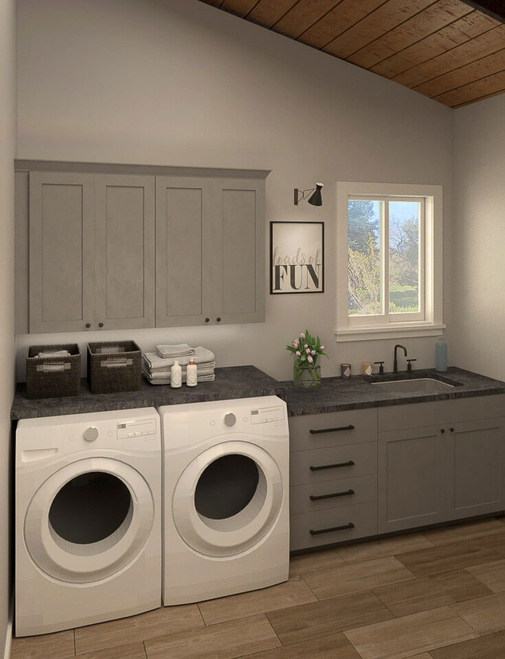 The image shows a modern kitchen with clean, white appliances, including a washing machine, dishwasher, and oven, set against grey cabinets and a black countertop.