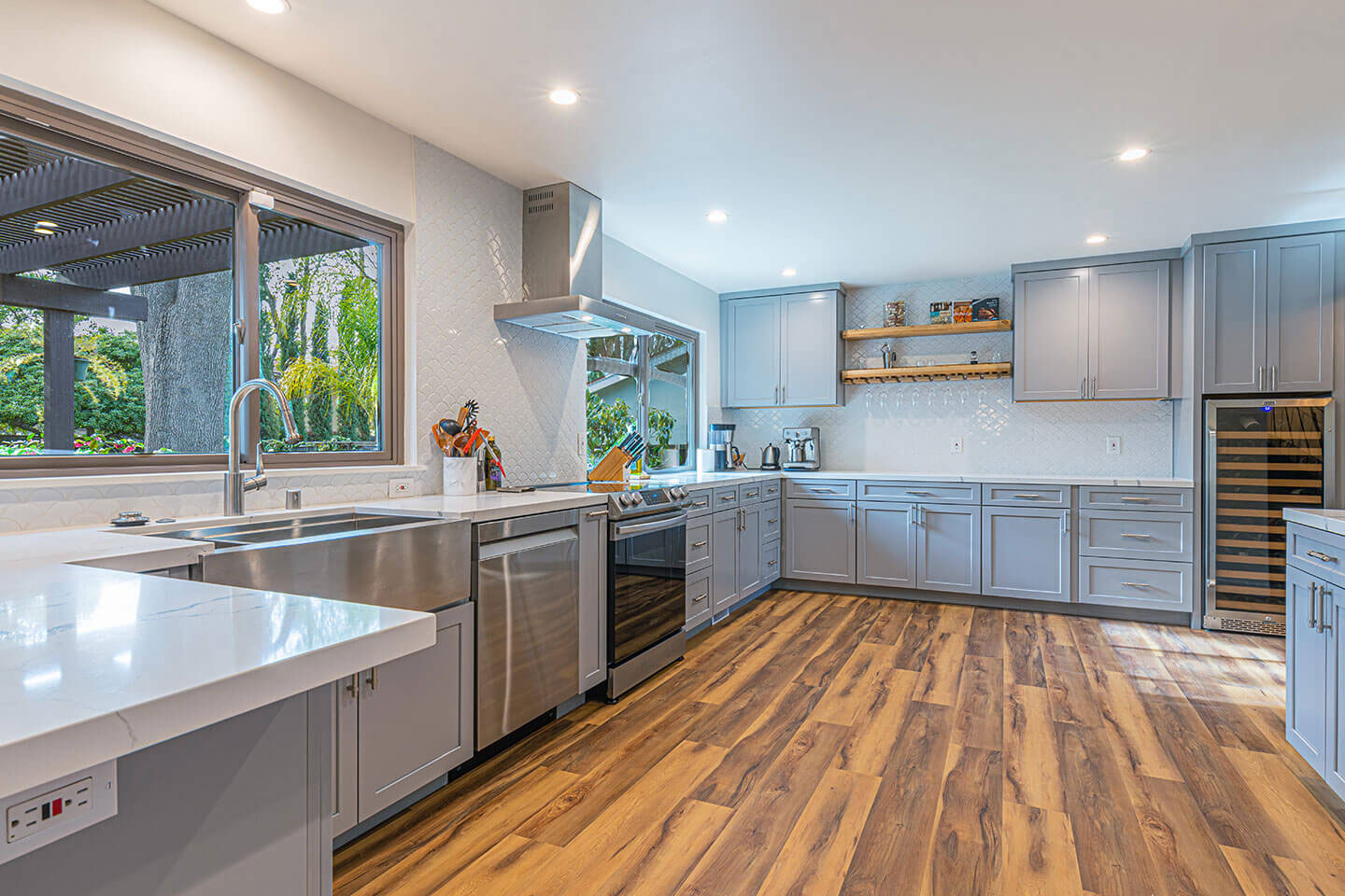 A modern kitchen with a combination of dark wood cabinets, stainless steel appliances, and a large island in the center.