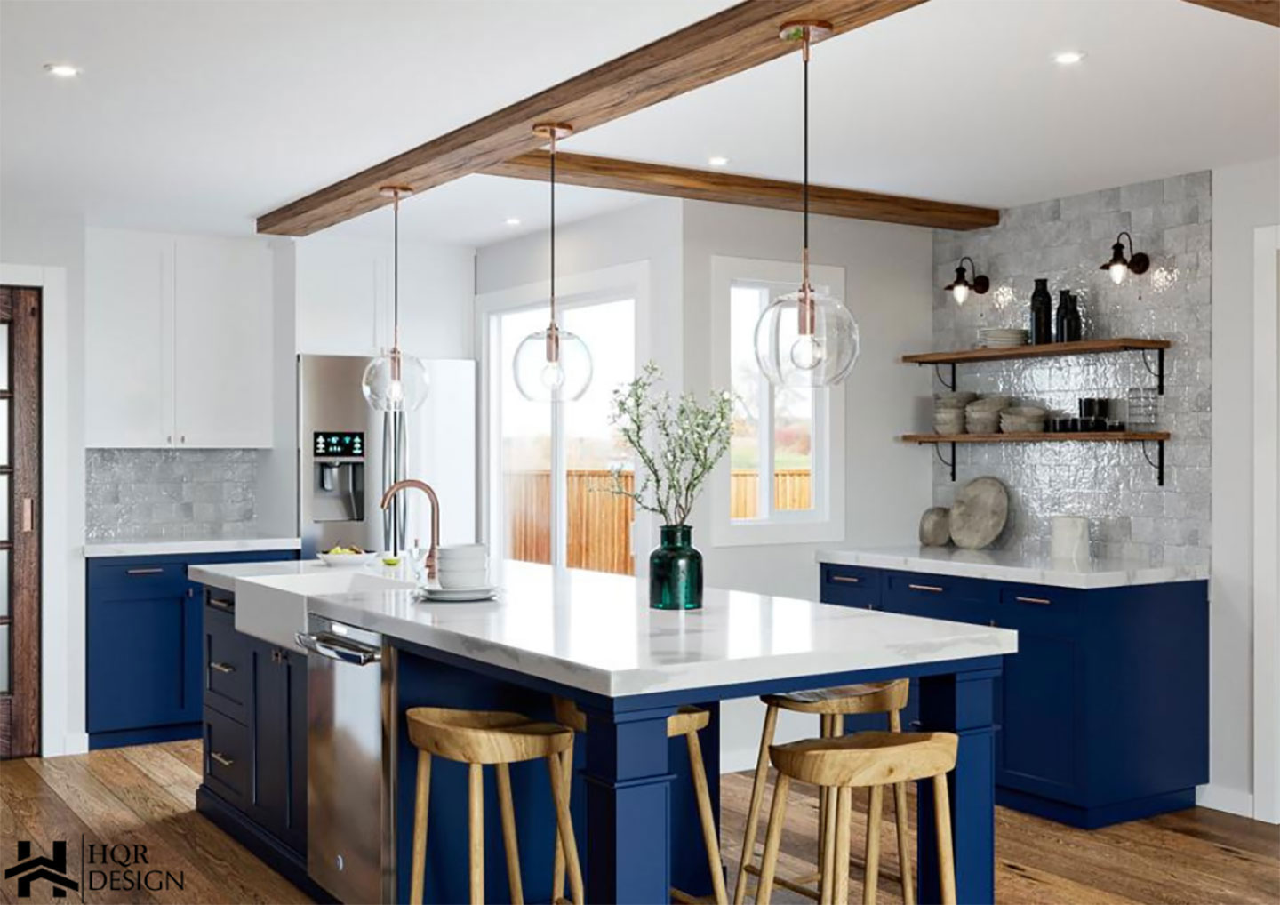 The image depicts a modern kitchen interior with blue cabinetry, stainless steel appliances, a central island, a large dining table, and a contemporary design aesthetic.